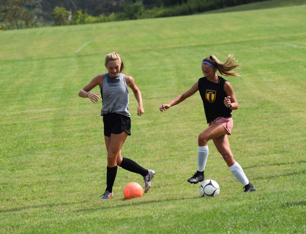 two grils play soccer
