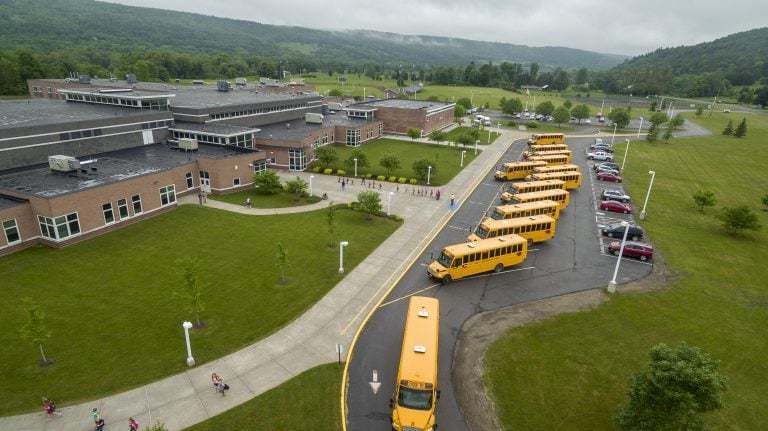 An aerial view of a school and school buses