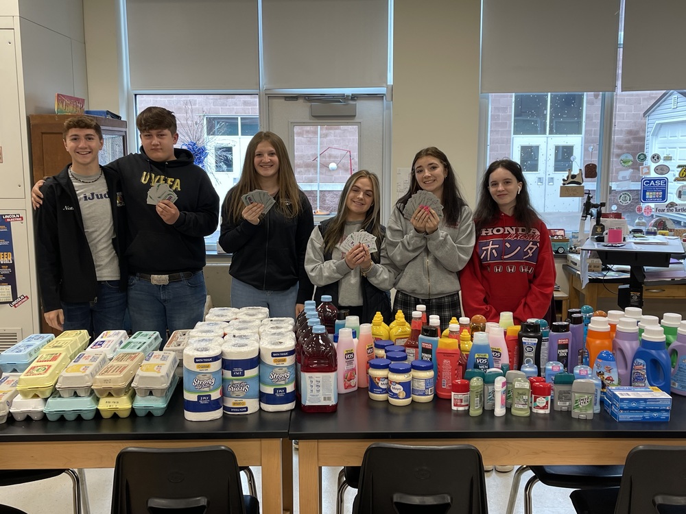 Six students stand in front of donated food