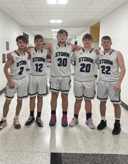 Five senior basketball players stand 