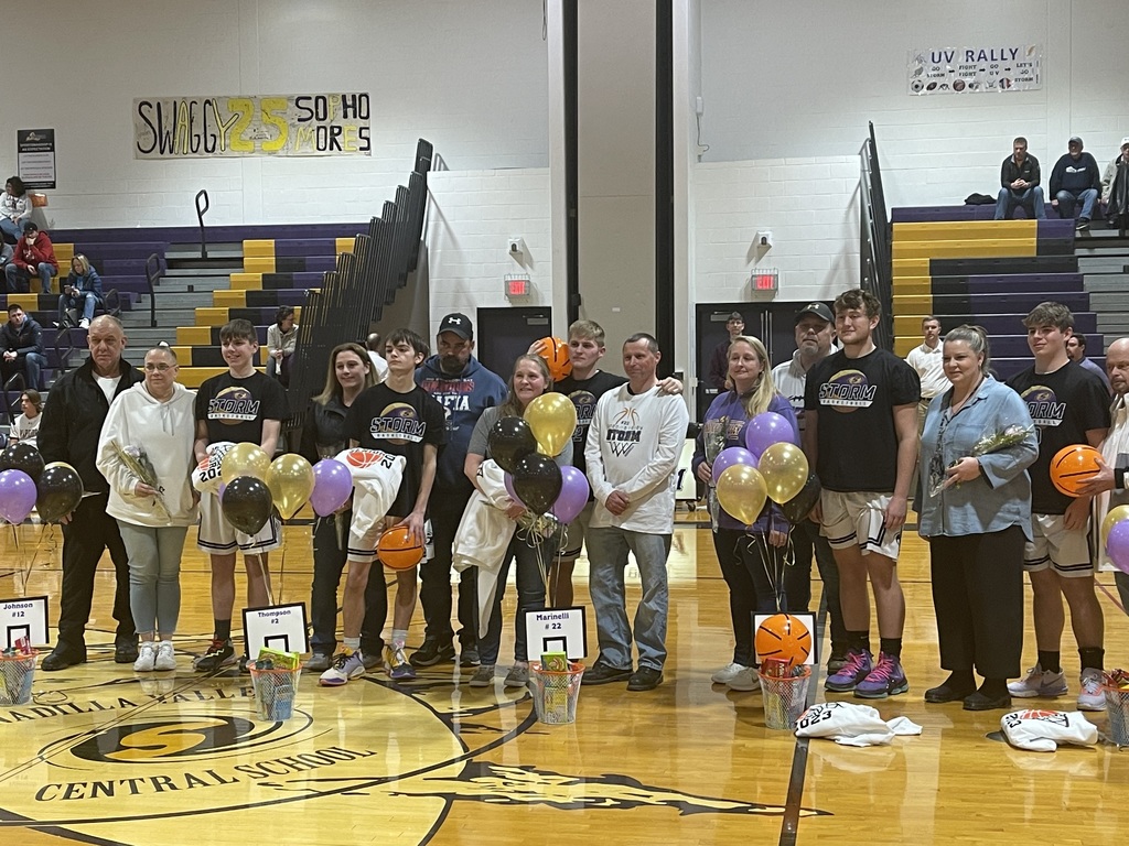 Five senior basketball players stand with their families